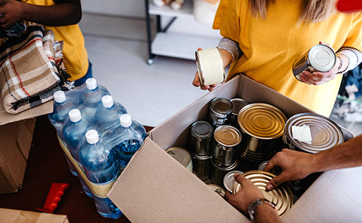 People loading canned goods into a box
