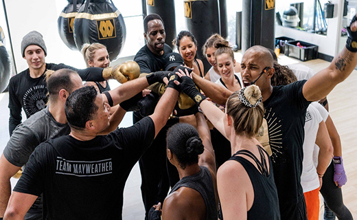 A large group in workout wear celebrating the end of a work out
