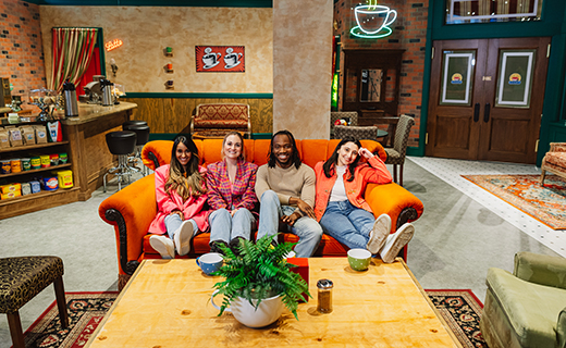 4 people sitting on couch in Central Perk set of the Friends Experience