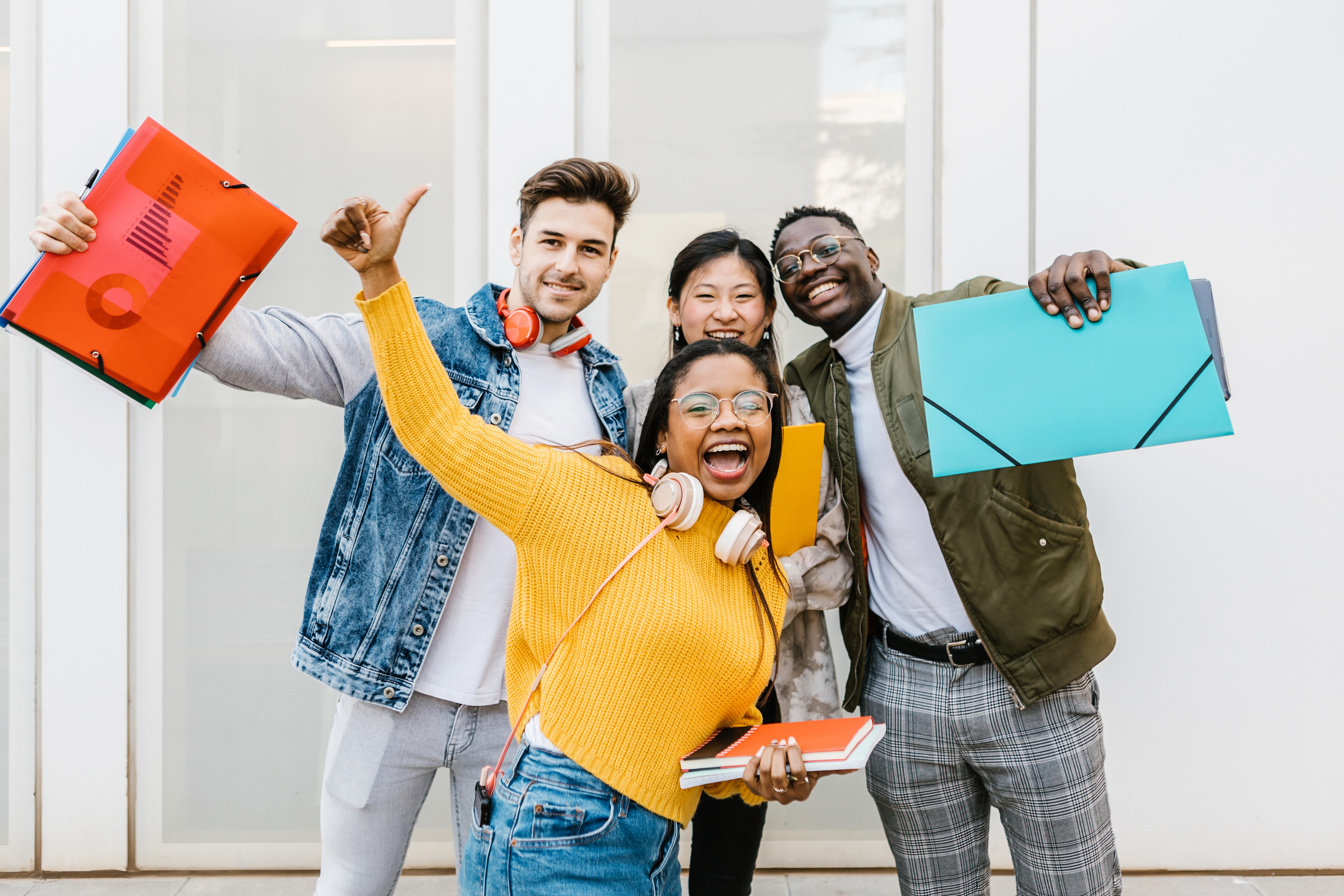 Students celebrating while holding notebooks