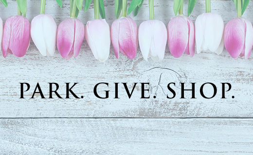 Tulips on wood background with text "Park. Give. Shop."