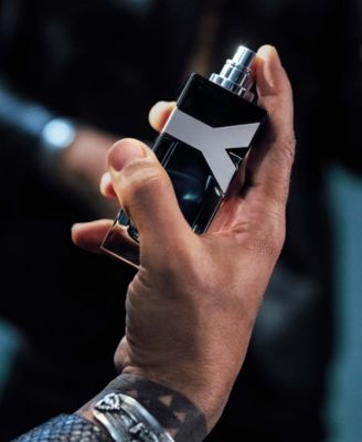 man's hand spraying YSL cologne