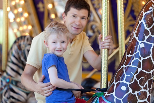 dad and son on merry go round
