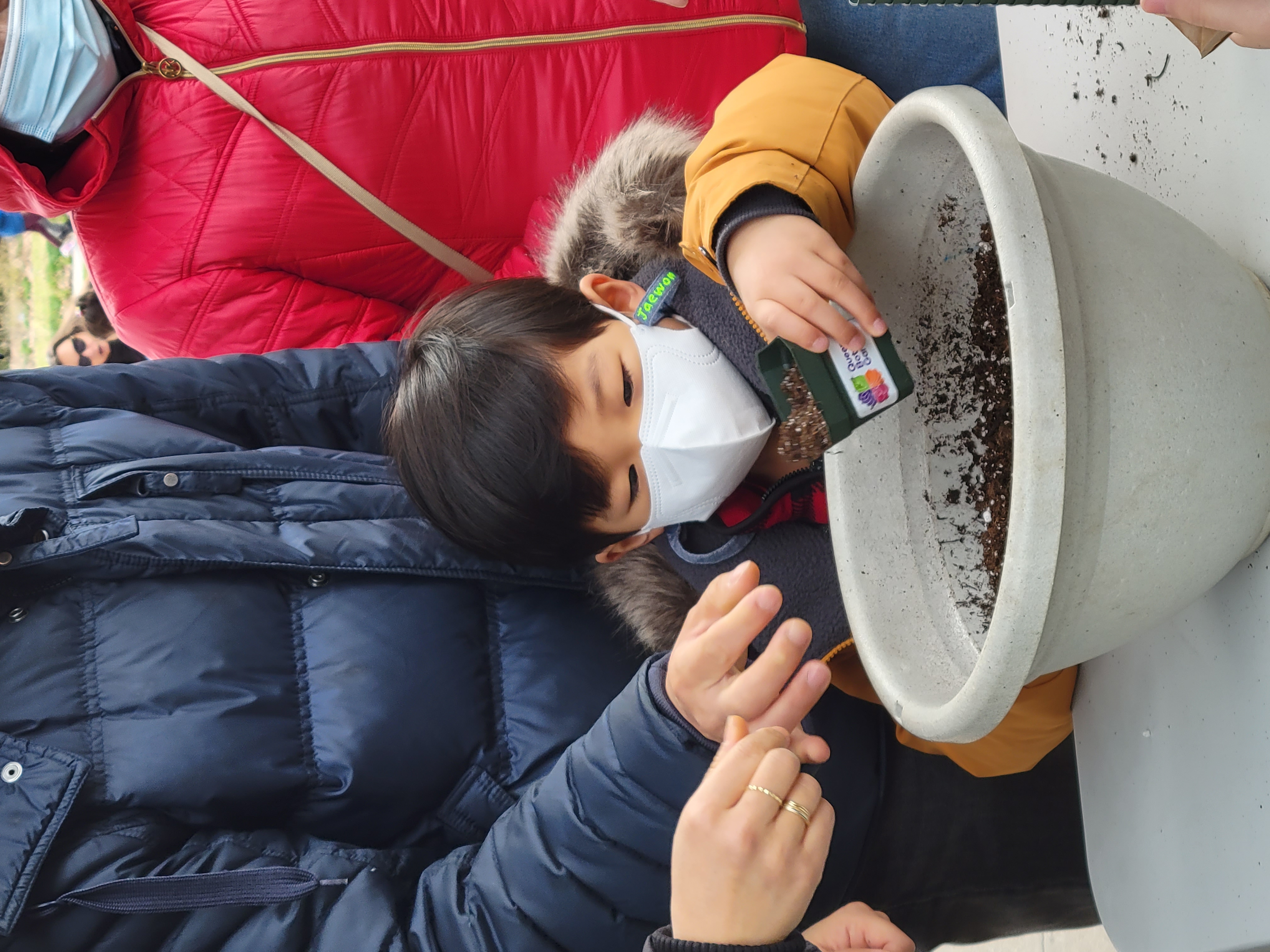 Child planting seeds in pot