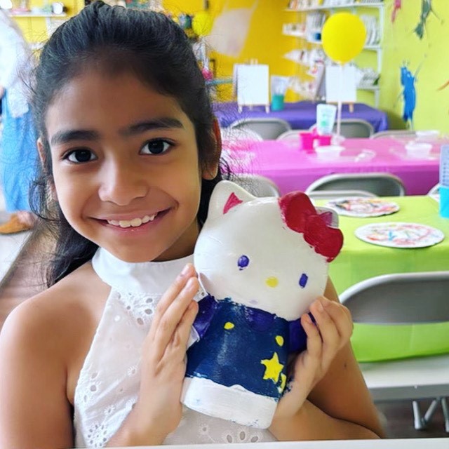 Young girl holding an Hello Kitty painted plaster 