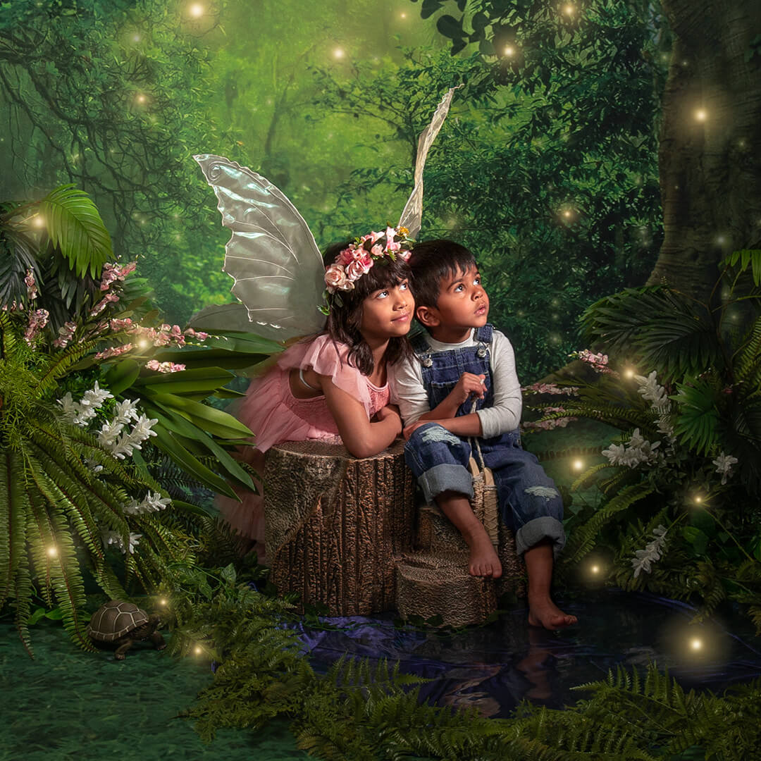 Boy and girl dressed as fairies in a magical forest.
