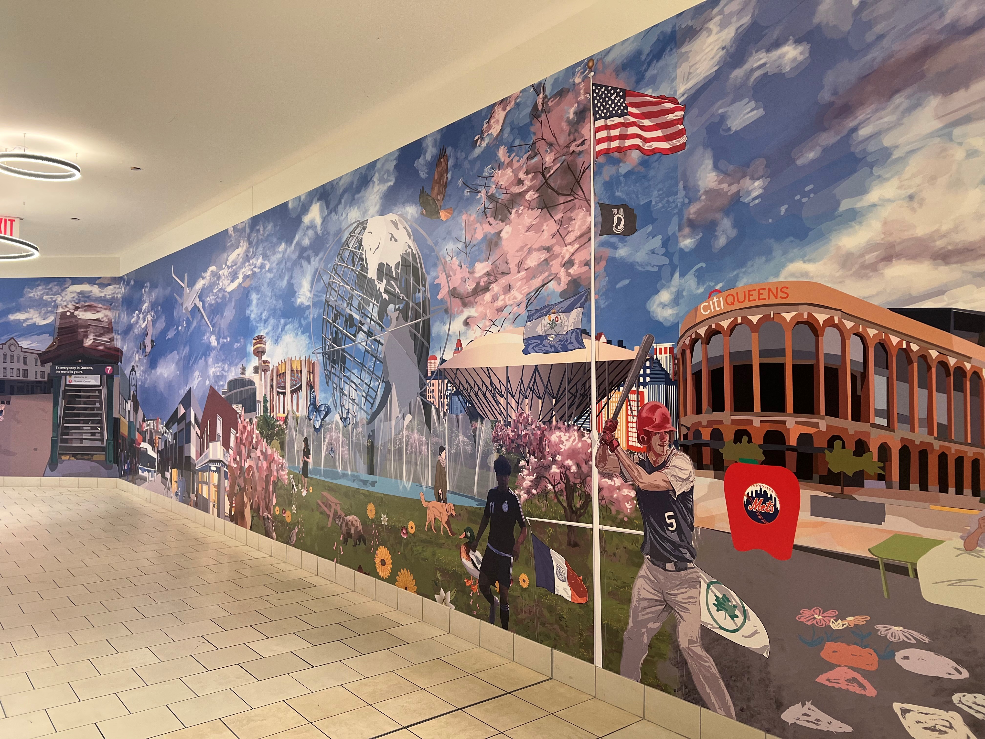 Picture of the Mural designed by the students at The High School for Arts and Business, this celebrates the rich cultural diversity and iconic landmarks of Queens, New York. Located Level 1, near Applebee's.
