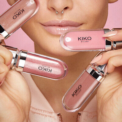 A woman holding multiple pink lip glosses from Kiko Milano