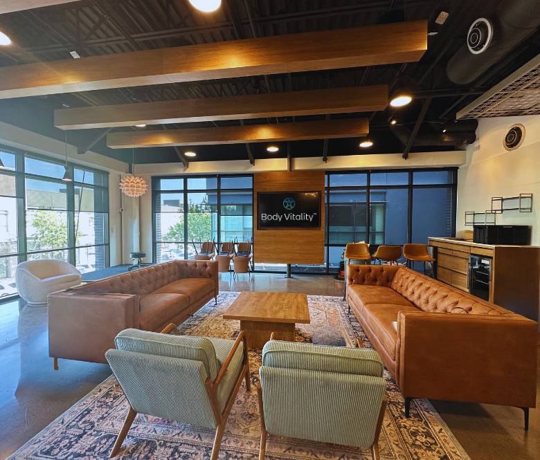 Waiting room with large windows, chairs, couches and rugs. 