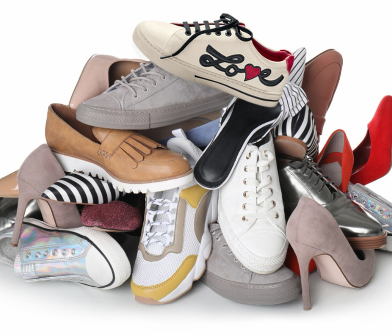 Assorted shoes piled on top of each other.