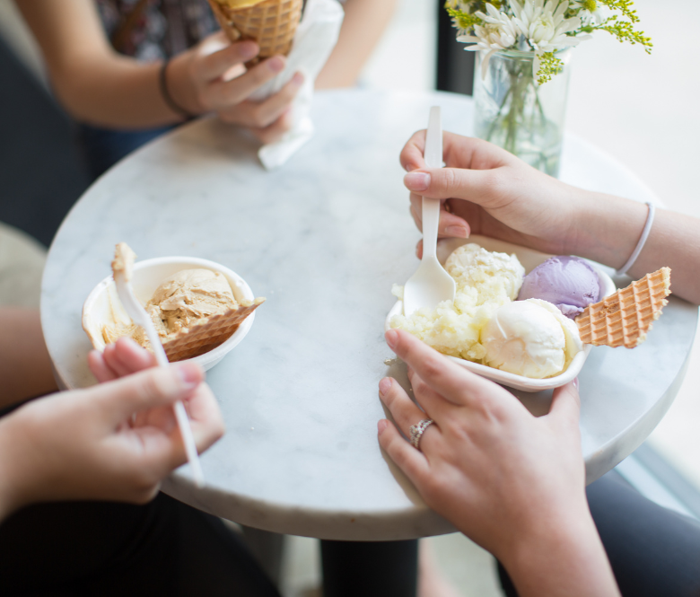Bowls of ice cream with waffle cone pieces on a table.