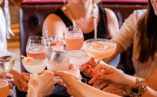 An assortment of cocktails being held up by people.