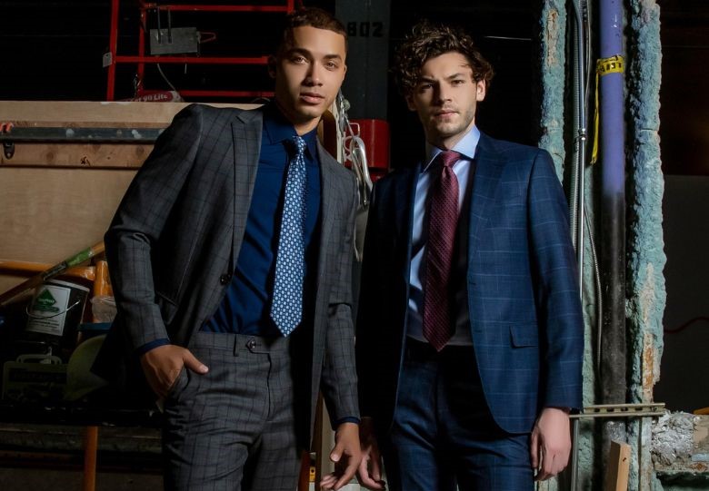 Two men posing in gray and blue fashionable suits. 