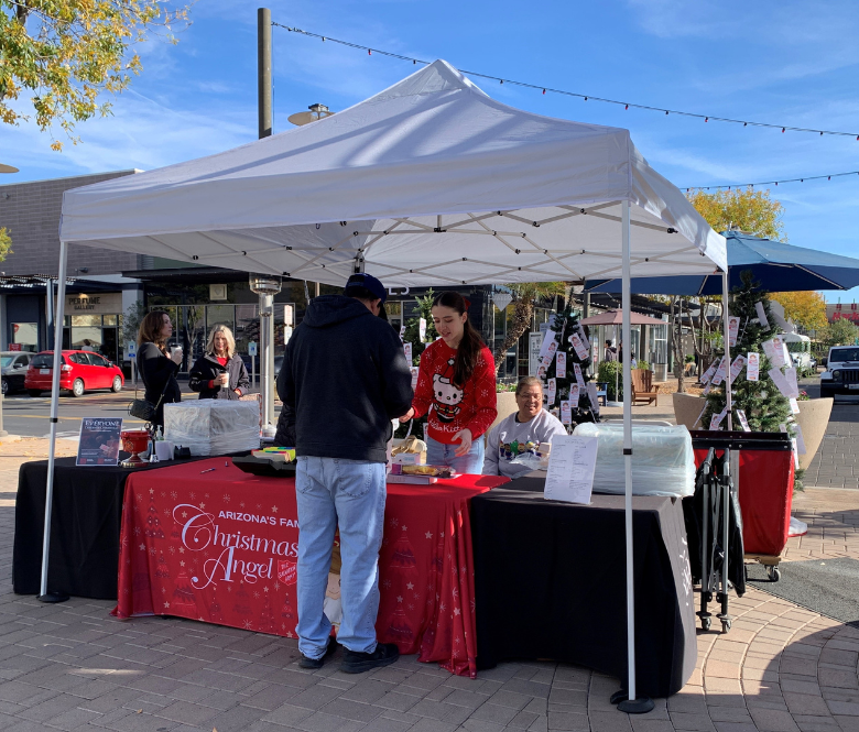 People at the Salvation Army tent speaking with volunteers.