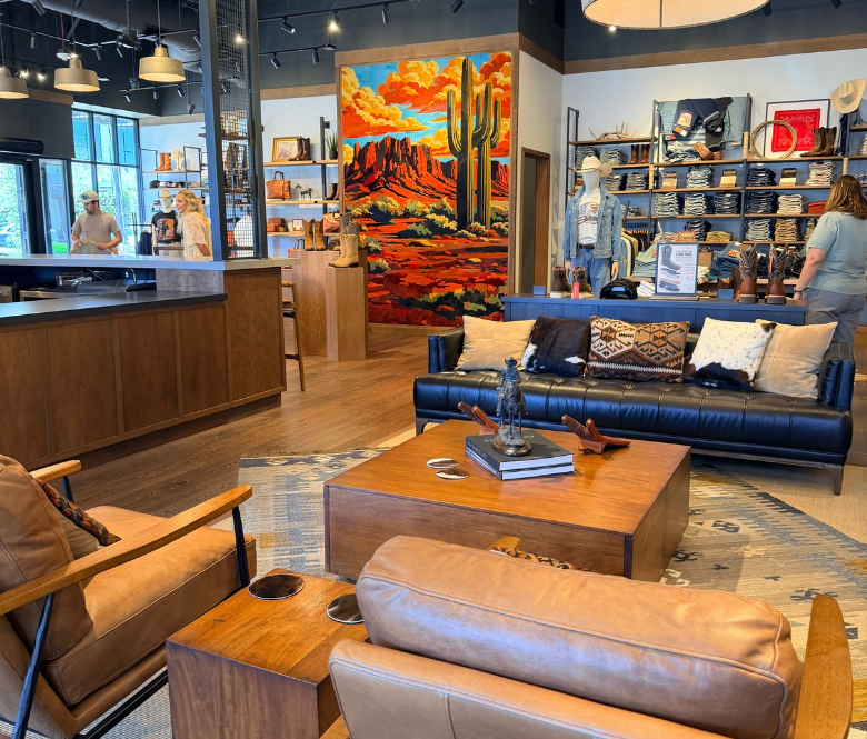 A boot store with an Arizona desert mural on the wall and couches in the center.