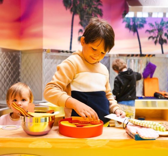 Boy and baby playing with play food toys