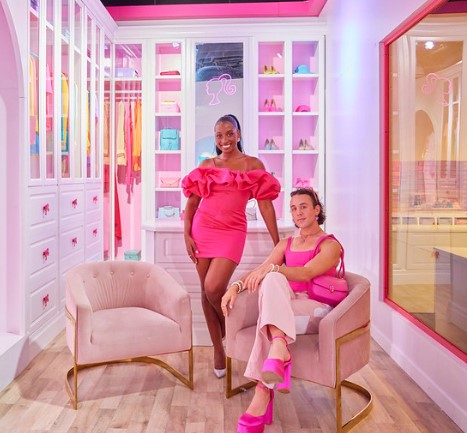 Man and woman posing in the Barbie pink closet