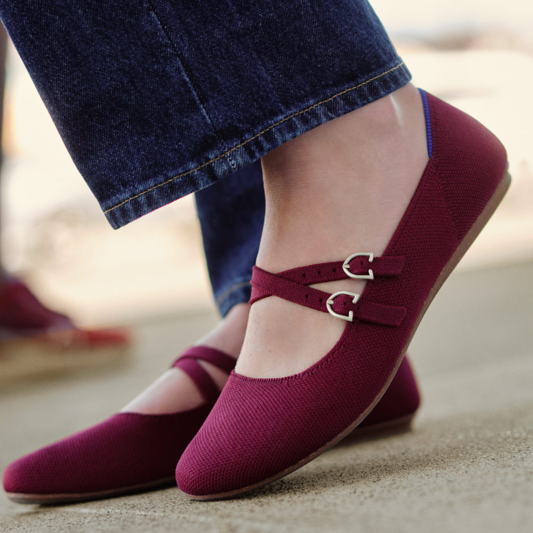 close up of woman's feet wearing maroon flats 