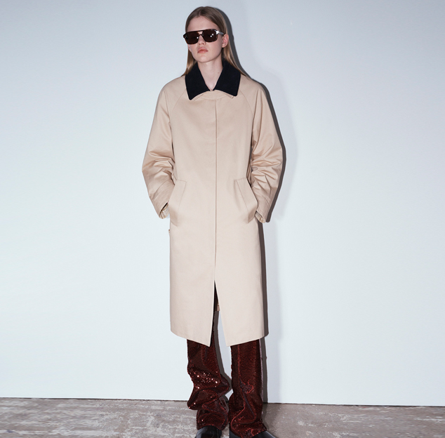 model posing on wall wearing jacket and sunglasses