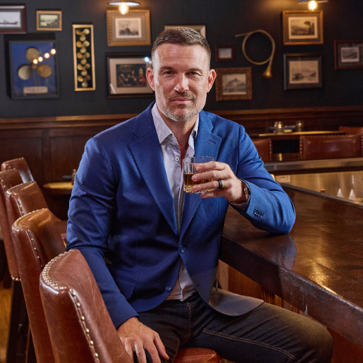 model posing on barstool holding a drink 
