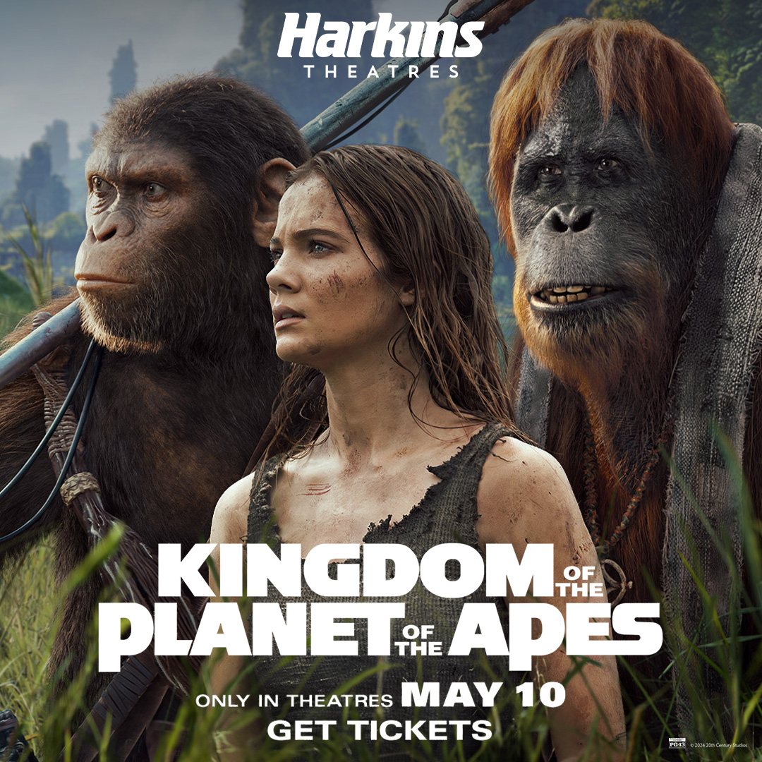 A GIRL STANDING IN BETWEEN TWO APES IN A JUNGLE 