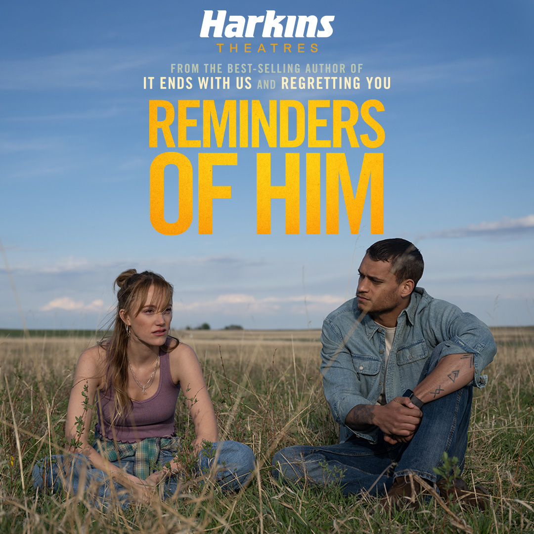 man and a woman sitting in a field 