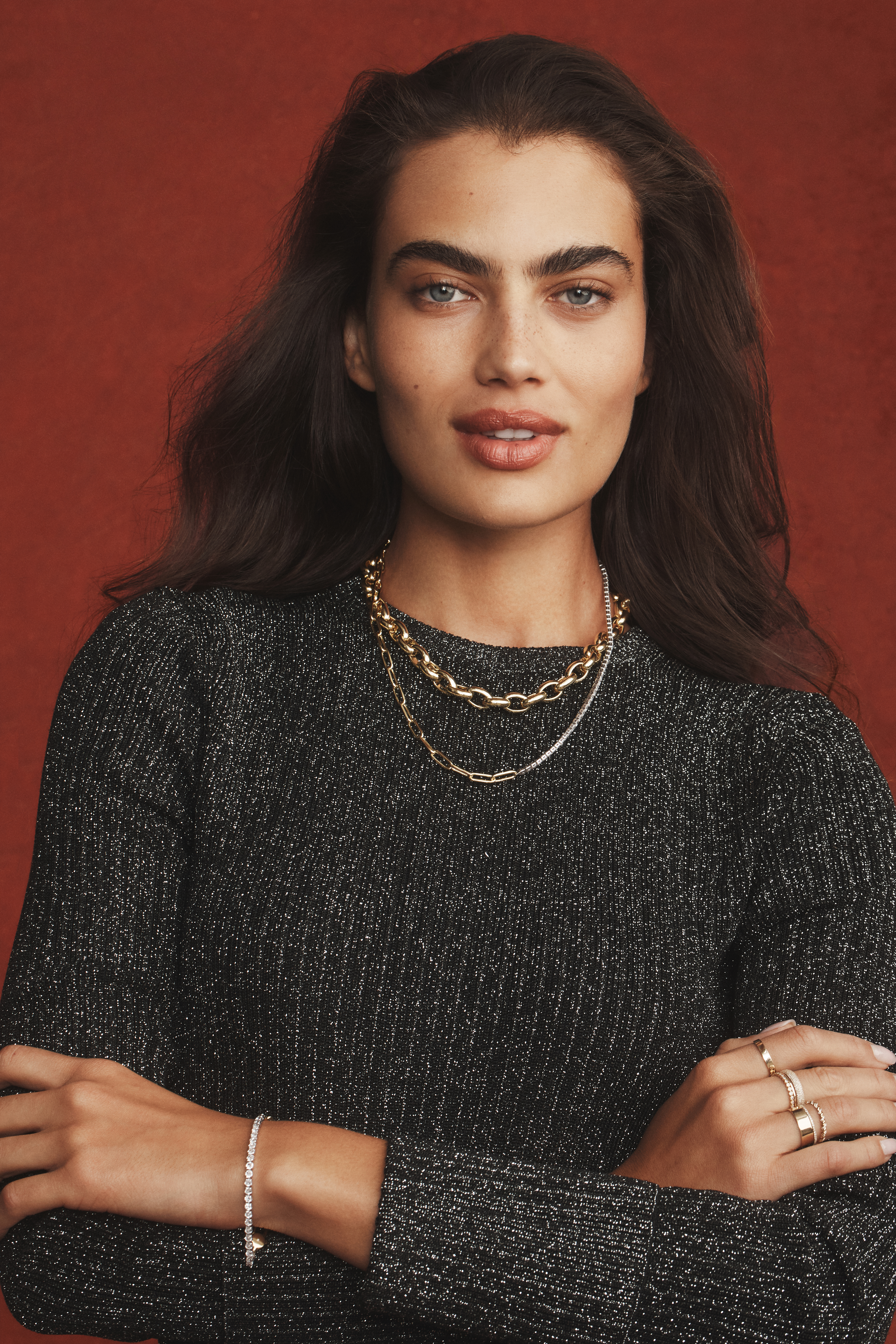 model wearing necklaces and bracelets and smiling 