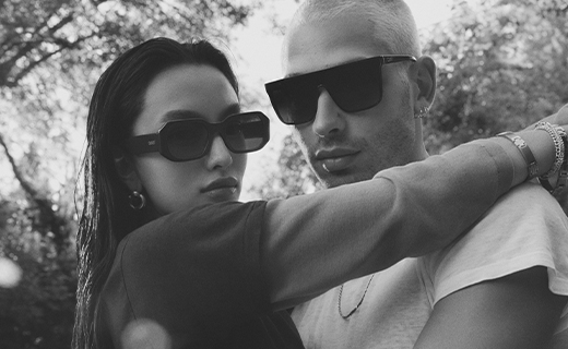 GUY WITH A WHITE TSHIRT AND GLASSES HUGGING A GIRL WITH SUNGLASSES ON