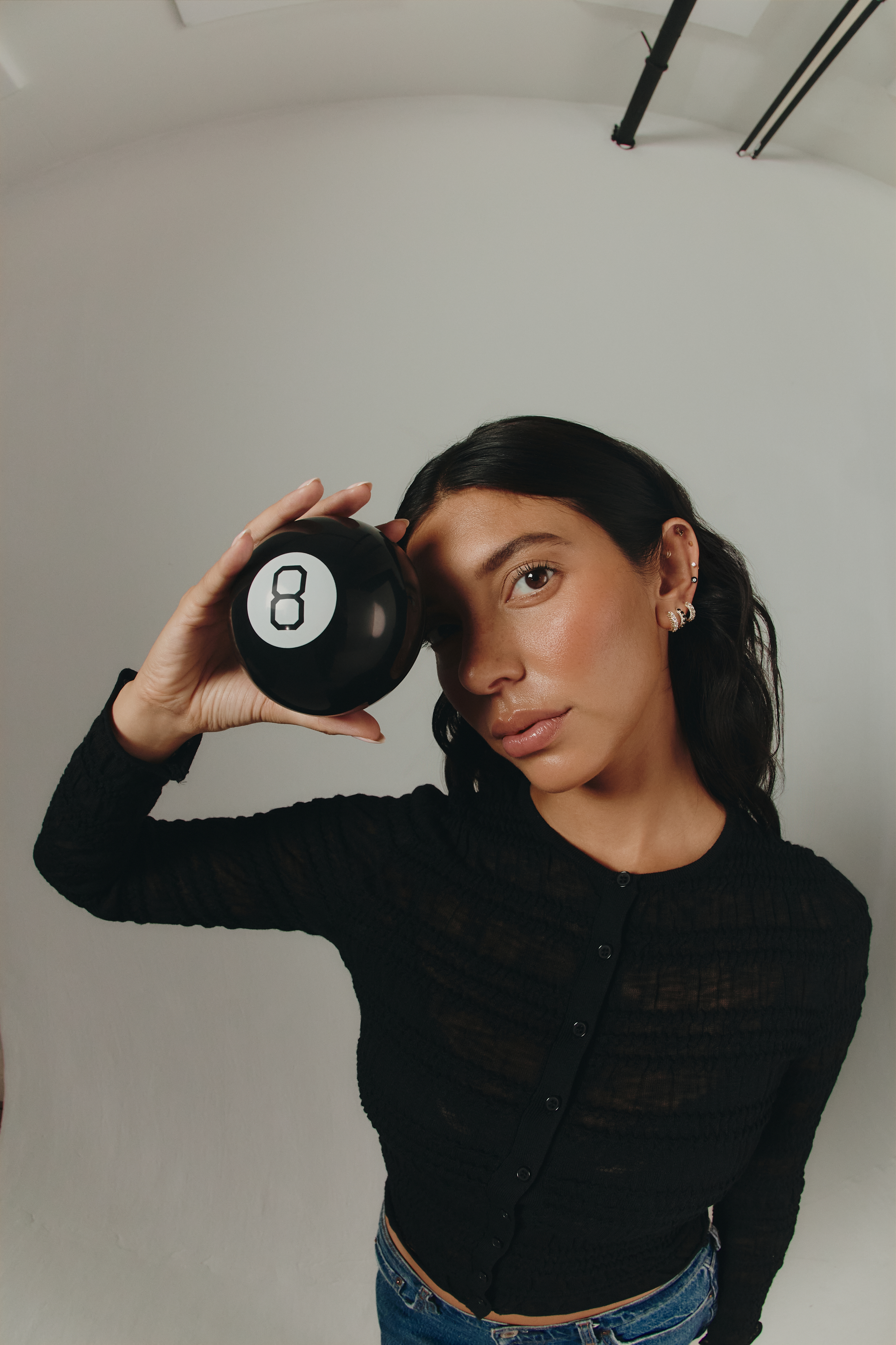girl holding magic 8 ball to her eye 