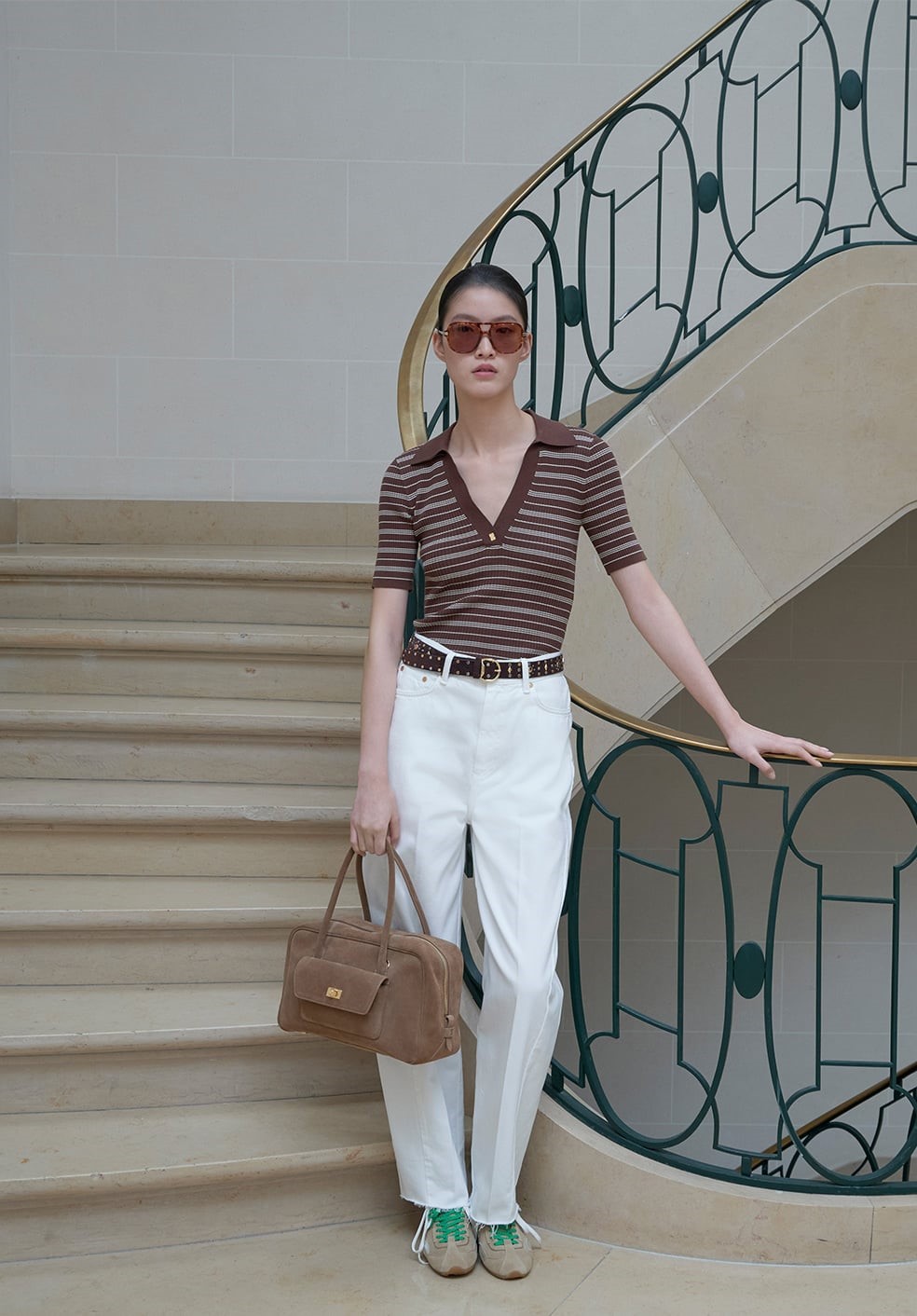 woman wearing paints and top standing on a stairway.