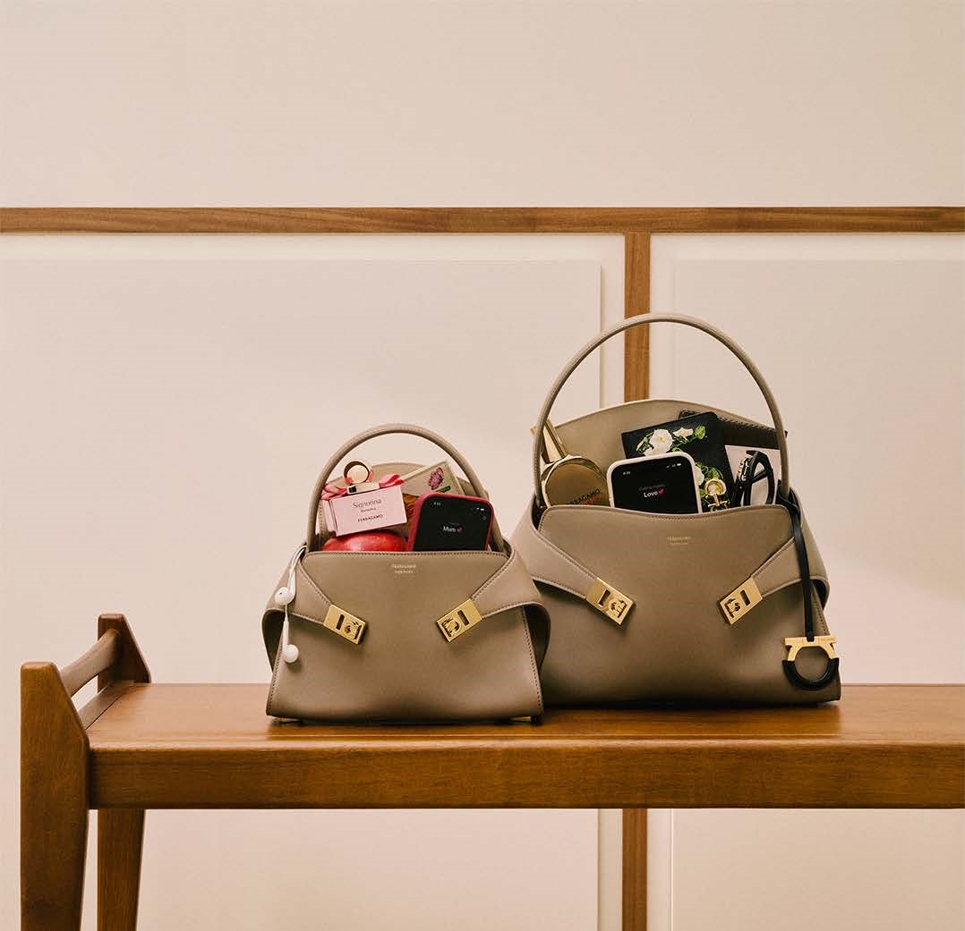 two handbags on a table filled with phones and ferragamo fragrances 