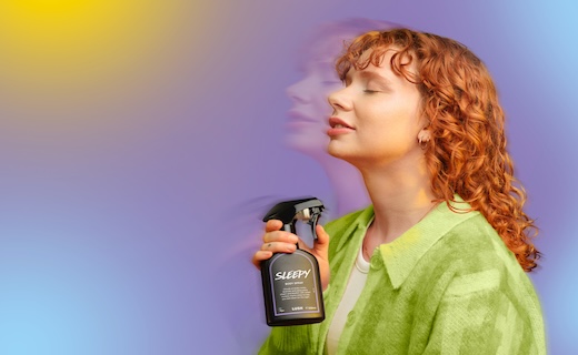 GIRL WITH RED HAIR SPRAYING LUSH PRODUCTS ON HER NECK. 