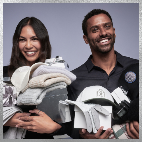 a man and woman holding hats, shirts, golf gloves all from travis mathews 