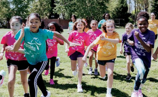 group of young girls running towards the camera smiling 
