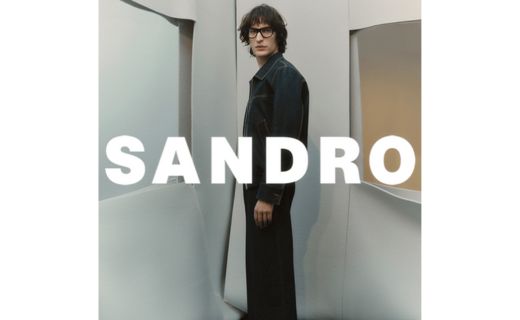 male model posing with sandro logo across him 