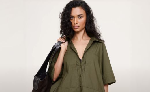 model in army green dress holding a black shoulder bag