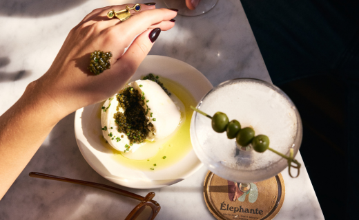 woman's hand with a caviar bump and a dirty martini