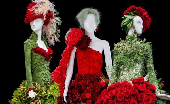 three mannequins decorated in red and green fresh flowers