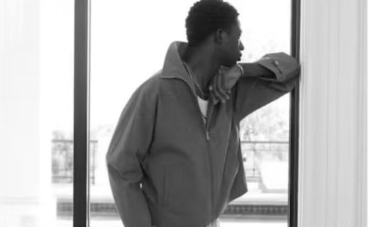 black and white photo of model looking out of a window 