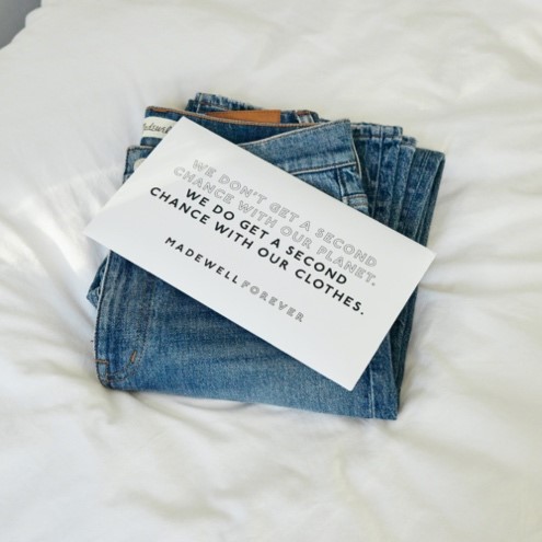 stack of jeans with a note on top that reads we don't get a second chance with our planet. We do get a second chance with our clothes. Madewell Forever