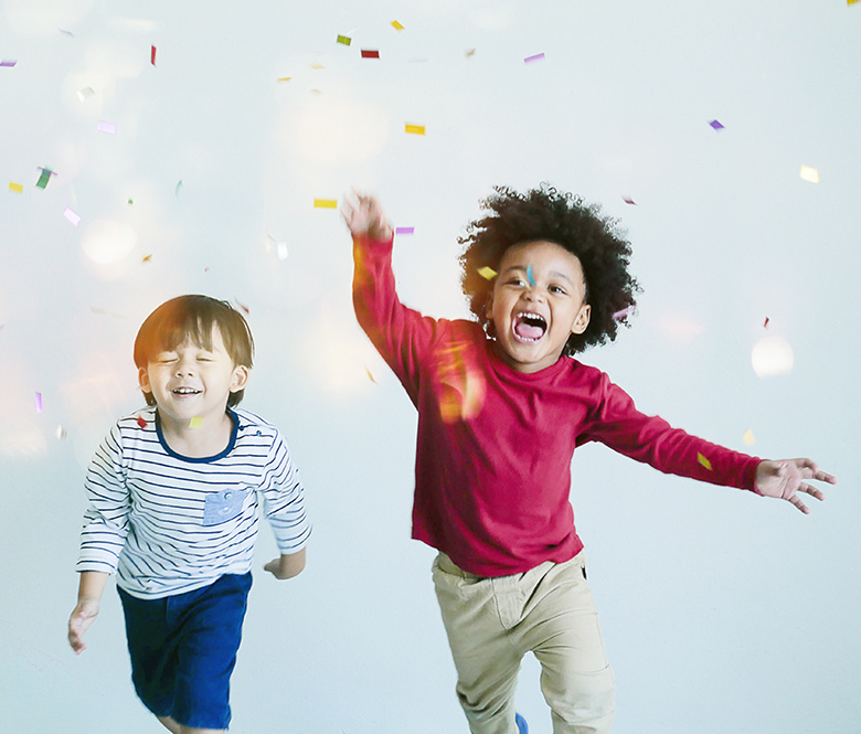 Two kids running under falling confetti 