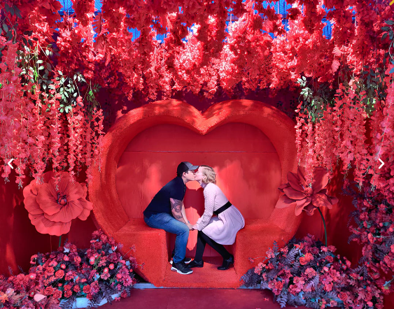 Large heart photo opp with couple sitting and kissing. 