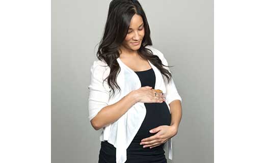 Soon-to-be Mom in a black and white outfit cradling her baby bump.