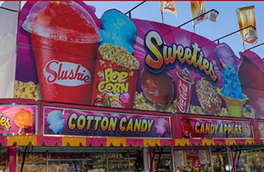 Concession stand with words: cotton candy, candy apples, Slushie, popcorn, and sweeties. 