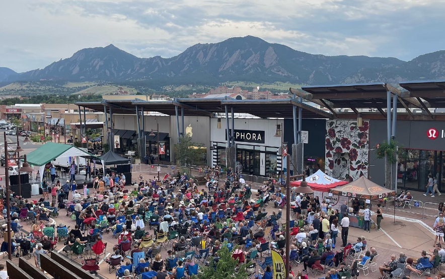 Large concert crowd on the street with mountains in the background.