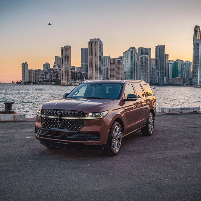 suv parked in front of a city skyline