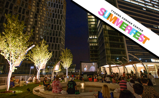 A crowd sitting on Tysons Corner Center Plaza while watching a movie.