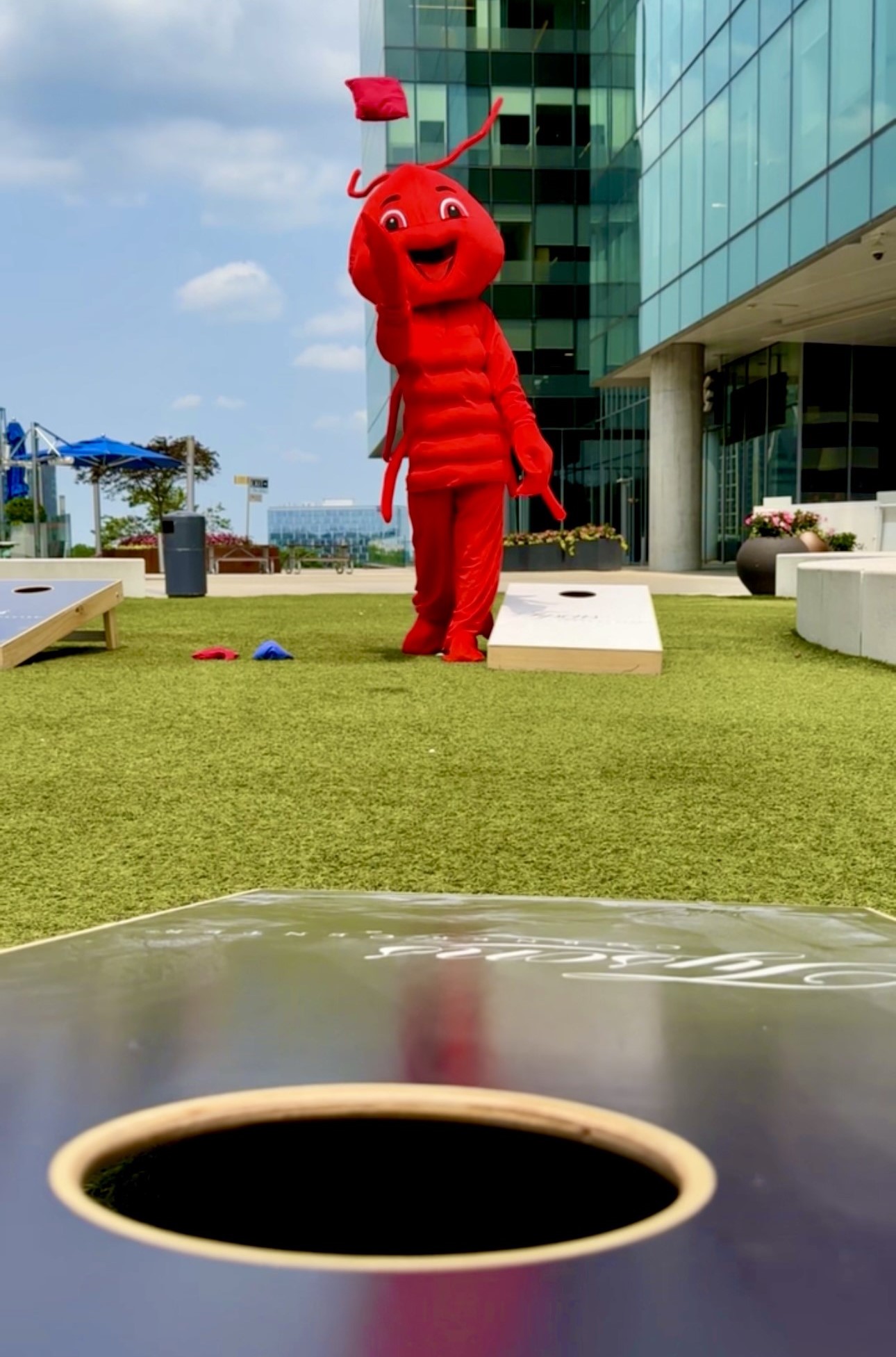 crawfish mascot tosses cornhole bean bag