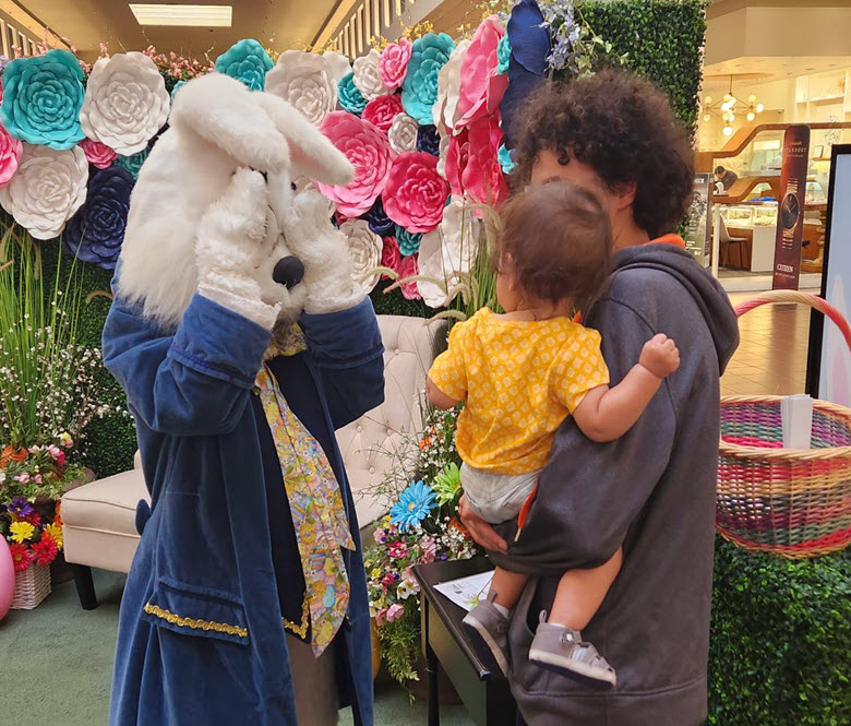 A young child and adult visiting the Easter bunny.