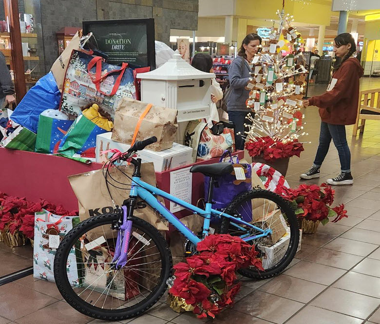 A big red donation box filled with gifts.